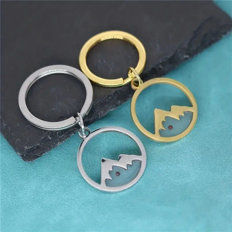 Schlüsselanhänger Mountains kurz, hochwertig gefertigt, zeigt ein goldenes Bergmotiv, ideal als stilvolles Accessoire für Schlüssel.