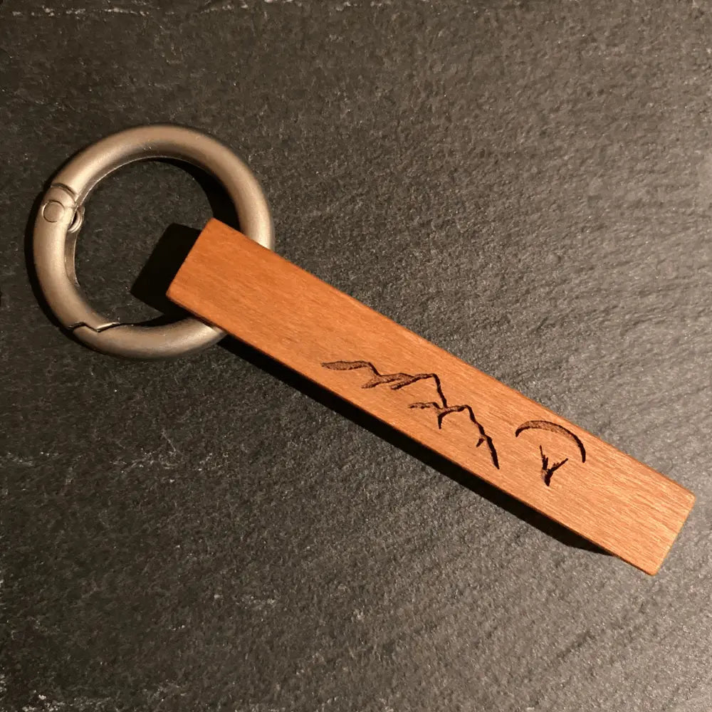 Echtholz Schlüsselanhänger I Love Paragliding aus Kirschholz mit Gravur und Gleitschirmmotiv, befestigt an einem matten Aluring.