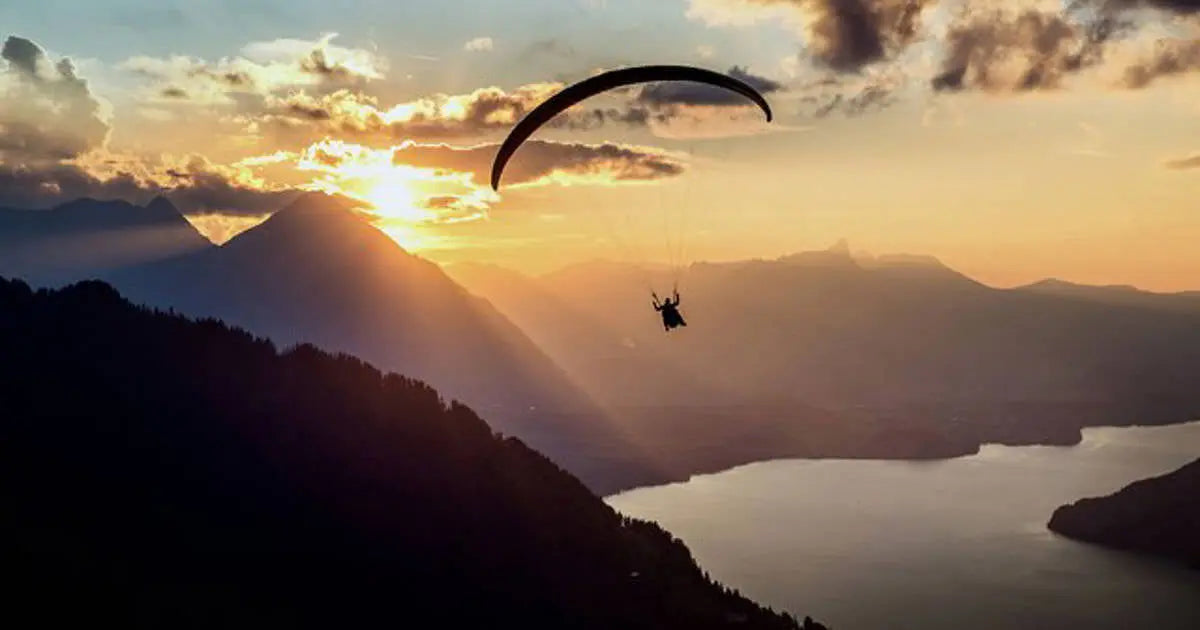 Gleitschirmflieger in wunderschöner Natur über Schweizer See in Abenddämmerung