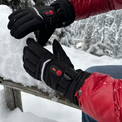 Person mit Savior HEAT Gloves Heizhandschuh im Schnee, zeigt die wasserdichten, touchscreen-kompatiblen Eigenschaften und die Heizfunktion für kalte Bedingungen.