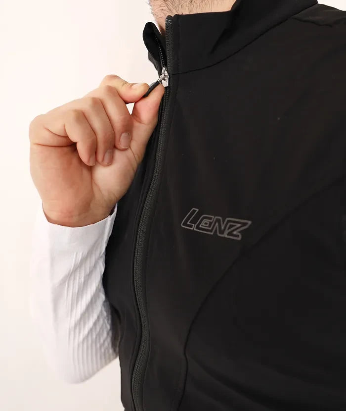 Lenz HEAT Vest 1.0 SET: Nahaufnahme einer Hand, die den Reißverschluss einer Heizweste hält, ideal für Outdoor-Aktivitäten, flexibel und windabweisend.