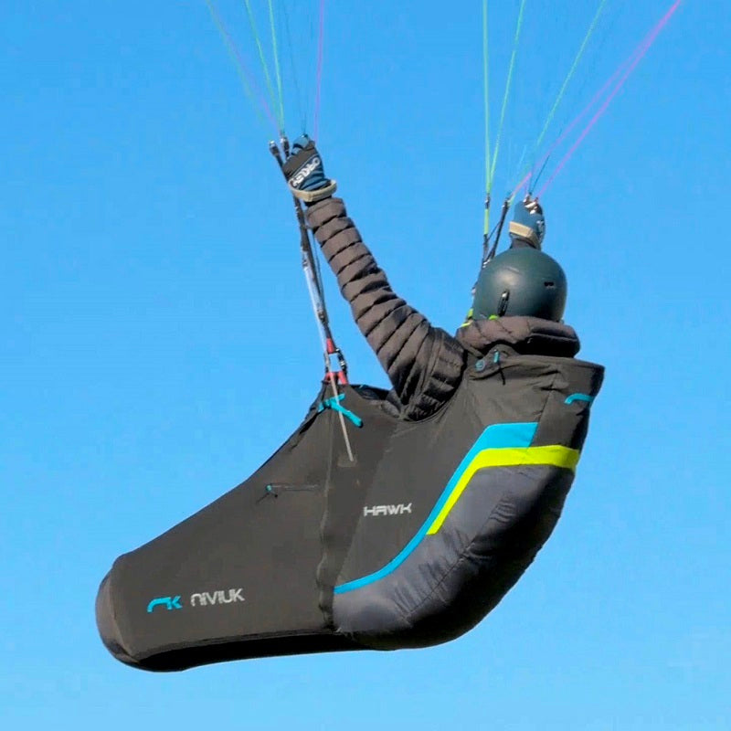 Person paragliding mit Niviuk Hawk, einem komfortablen Liegegurtzeug für lange Flüge, ideal für mittlere bis weite Strecken.