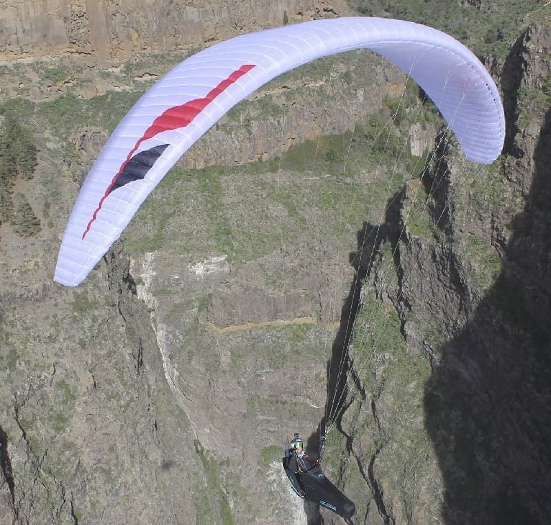 Niviuk Klimber 3P (EN-D) beim Paragliding über einer Klippe, ideal für erfahrene Piloten, die Leistung und Stabilität in der Luft suchen.