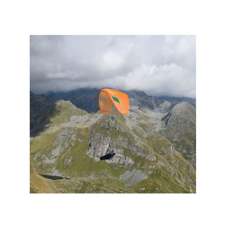 Niviuk Hook 6 P Gleitschirm im Flug über Berglandschaft, zeigt herausragende Thermikeigenschaften und intuitives Handling für vielseitiges Paragliding-Erlebnis.