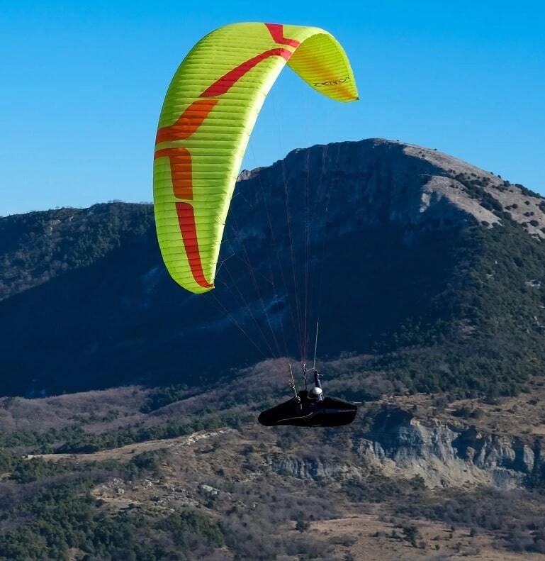 Ozone Zeno 2 (EN-D) Gleitschirm über Berglandschaft, ideal für erfahrene XC-Piloten, bekannt für exzellente Leistung und hohe Geschwindigkeiten.