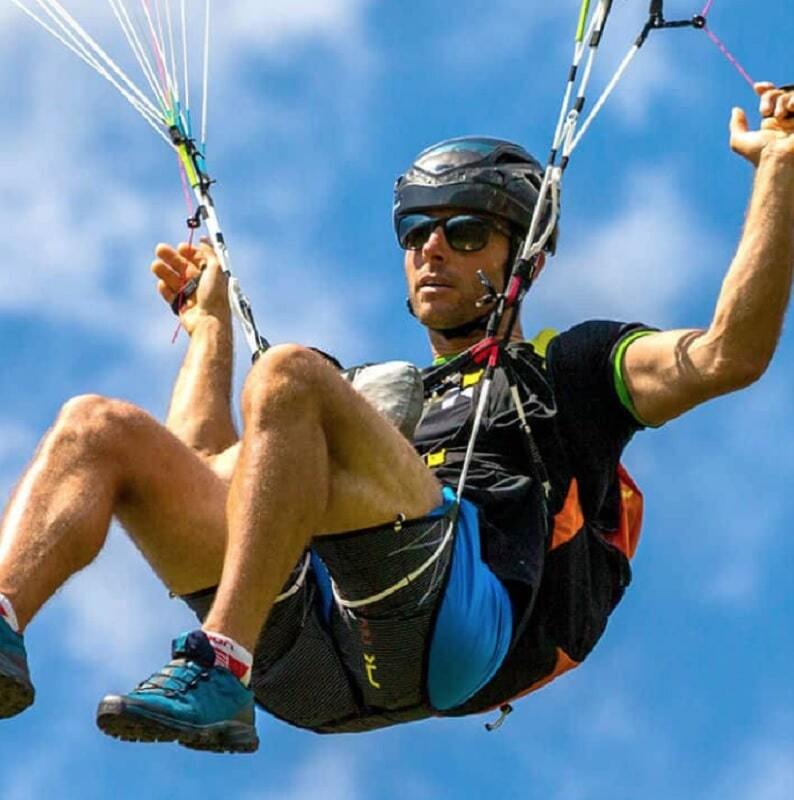 Niviuk Roamer P ultraleicht Gurtzeug beim Paragliding, Mann mit Helm und Fallschirm, ideal für Hike &amp; Fly-Enthusiasten. Ergonomisch und kompakt für Outdoor-Abenteuer.