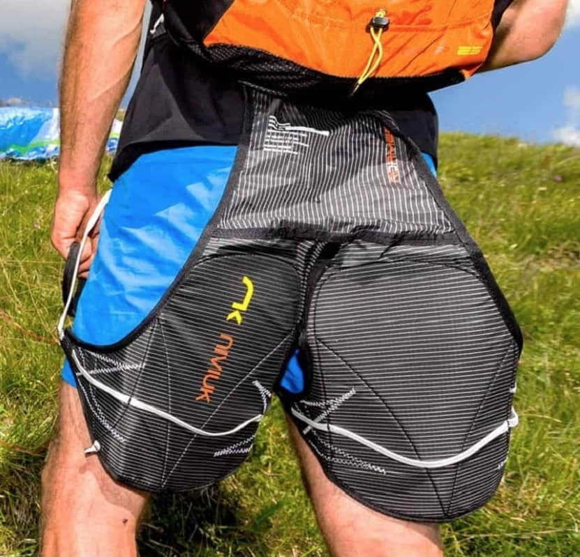 Person mit Shorts und Rucksack trägt das ultraleichte Niviuk Roamer P Gurtzeug, ideal für Hike &amp; Fly; ergonomisch und kompakt.