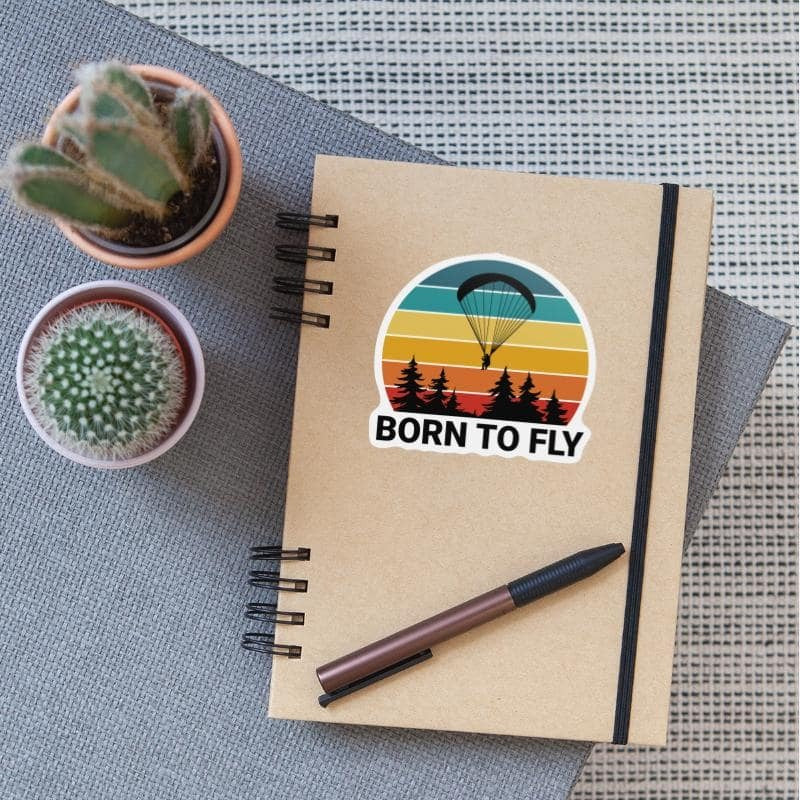 Sticker Paragliding - Born to Fly: Illustration einer Person beim Paragliden, ideal für glatte Oberflächen, langlebig und wasserfest, aus hochwertigem Vinyl.