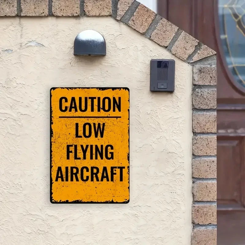 Retro-Schild Low flying Aircraft aus Metall mit schwarzem Text auf gelbem Hintergrund, ideal als Wanddeko. Hochwertig verarbeitet, perfekt zum Aufhängen.