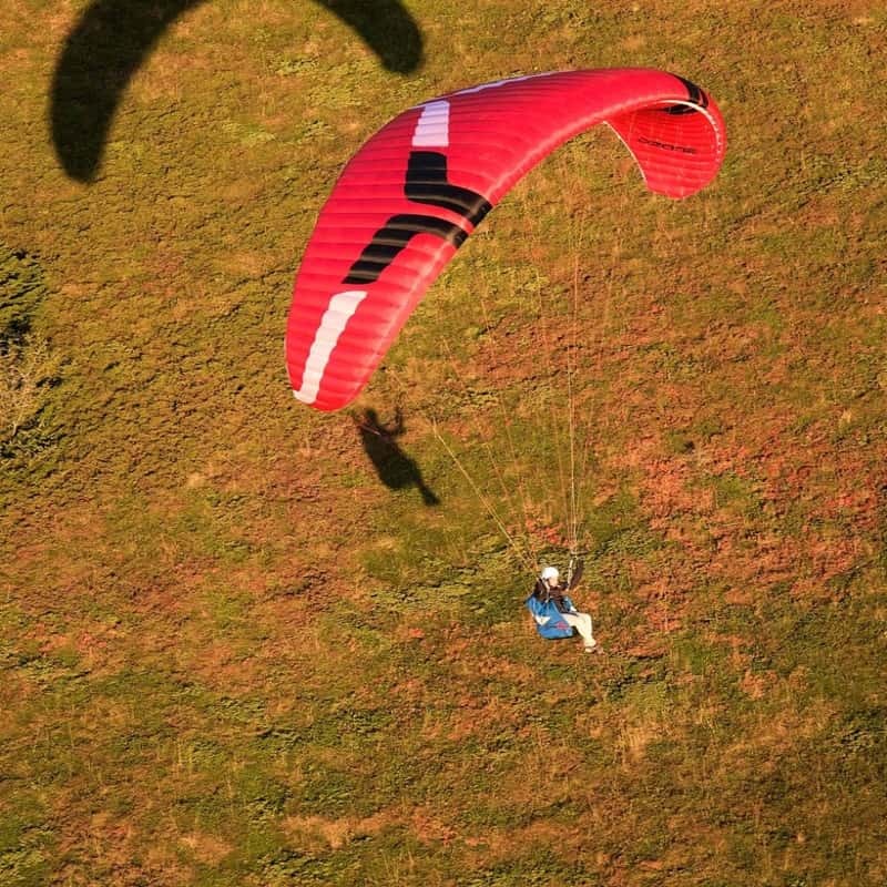 Ozone Geo 7 Gleitschirm über Wasser schwebend, ideal für Piloten, die Leichtigkeit und Leistung suchen. Perfekt für XC-Flüge und Hike & Fly Abenteuer.