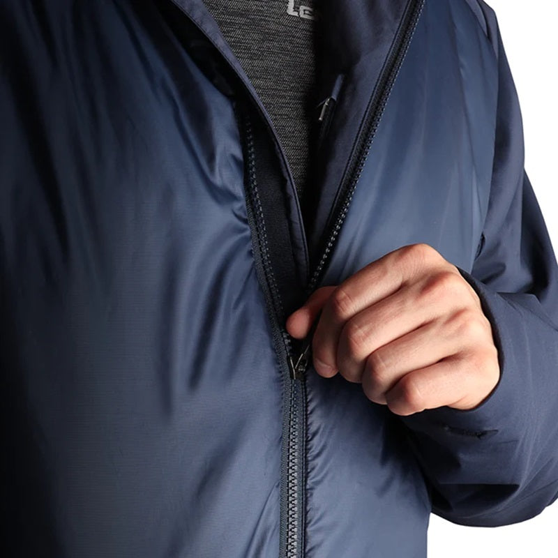 Person öffnet den Reißverschluss der Lenz HEAT Primaloft Jacket 2.0, einer isolierenden Jacke mit Primaloft Gold Insulation und wind- sowie wasserabweisender Oberfläche.