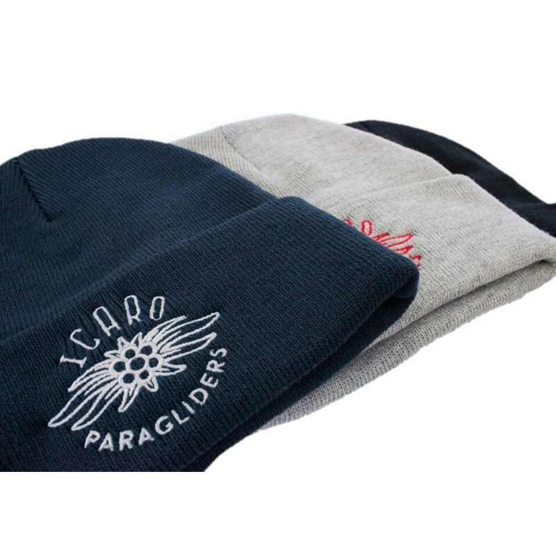 Icaro Beanie Mütze: Stapel gestrickter Mützen mit gesticktem Icaro-Logo, ideal für Gleitschirmflieger an kalten Tagen, bietet Wärme und stilvolle Passform.