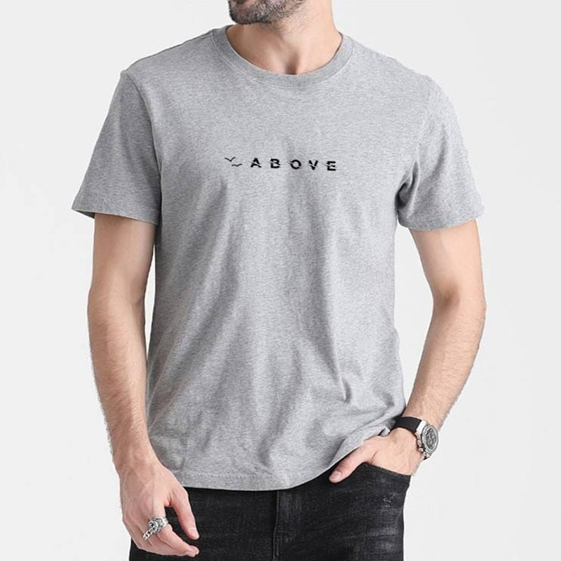 Mann trägt das Paragliding T-Shirt Above, ideal für Gleitschirmflieger, aus atmungsaktiver Baumwolle mit schlichtem Design und perfekter Passform.