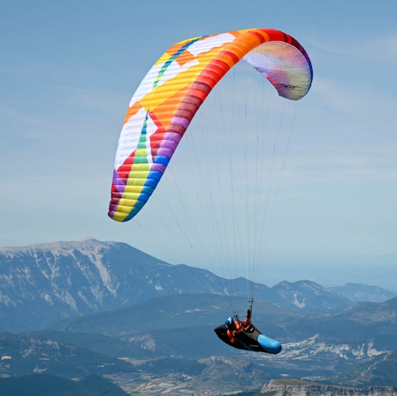 Person mit BGD Base 2 Light Gleitschirm schwebt über den Bergen, ideal für grenzenlose Hike-and-Fly-Abenteuer. Hochleistungsschirm mit präzisem Handling und geringem Gewicht.