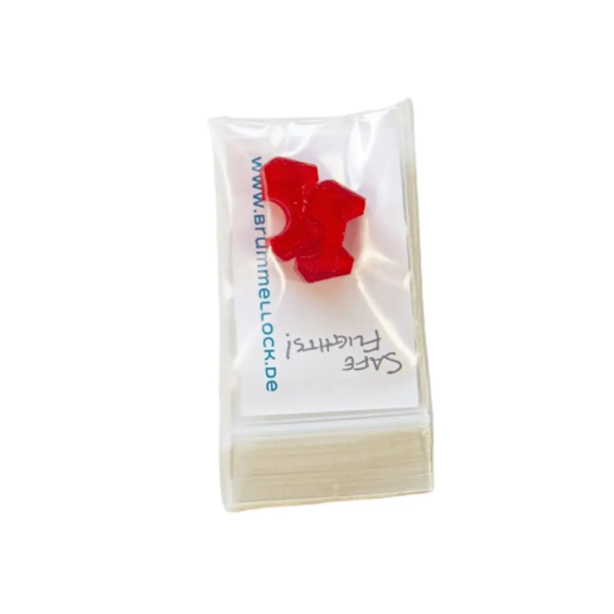Small red plastic safety component in a clear resealable bag labeled with a note, used as part of the Brummellock - Brummelhaken Sicherung for paragliding equipment.