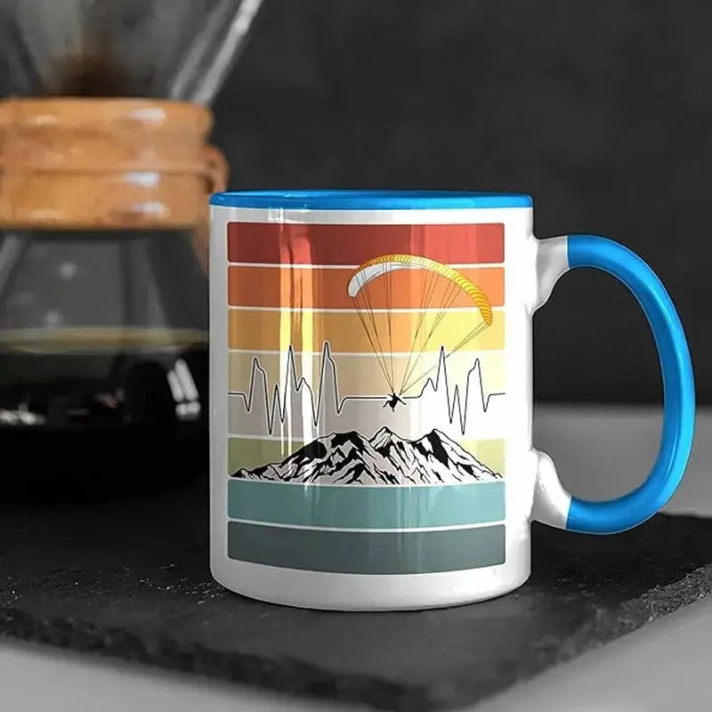 Gleitschirm Kaffee Tasse Rainbow mit Berg- und Gleitschirmmotiv, beidseitig bedruckt, 330ml, ideal für Büro oder Frühstück.