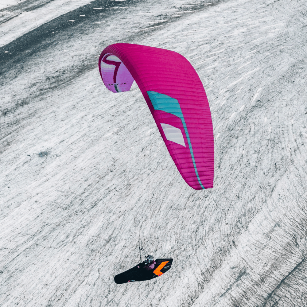 Niviuk Artik 7 P (EN-C) im Flug über verschneiter Landschaft, ideal für fortgeschrittene Hike &amp; Fly-Piloten, zeigt außergewöhnliche Leistung und leichte Handhabung.