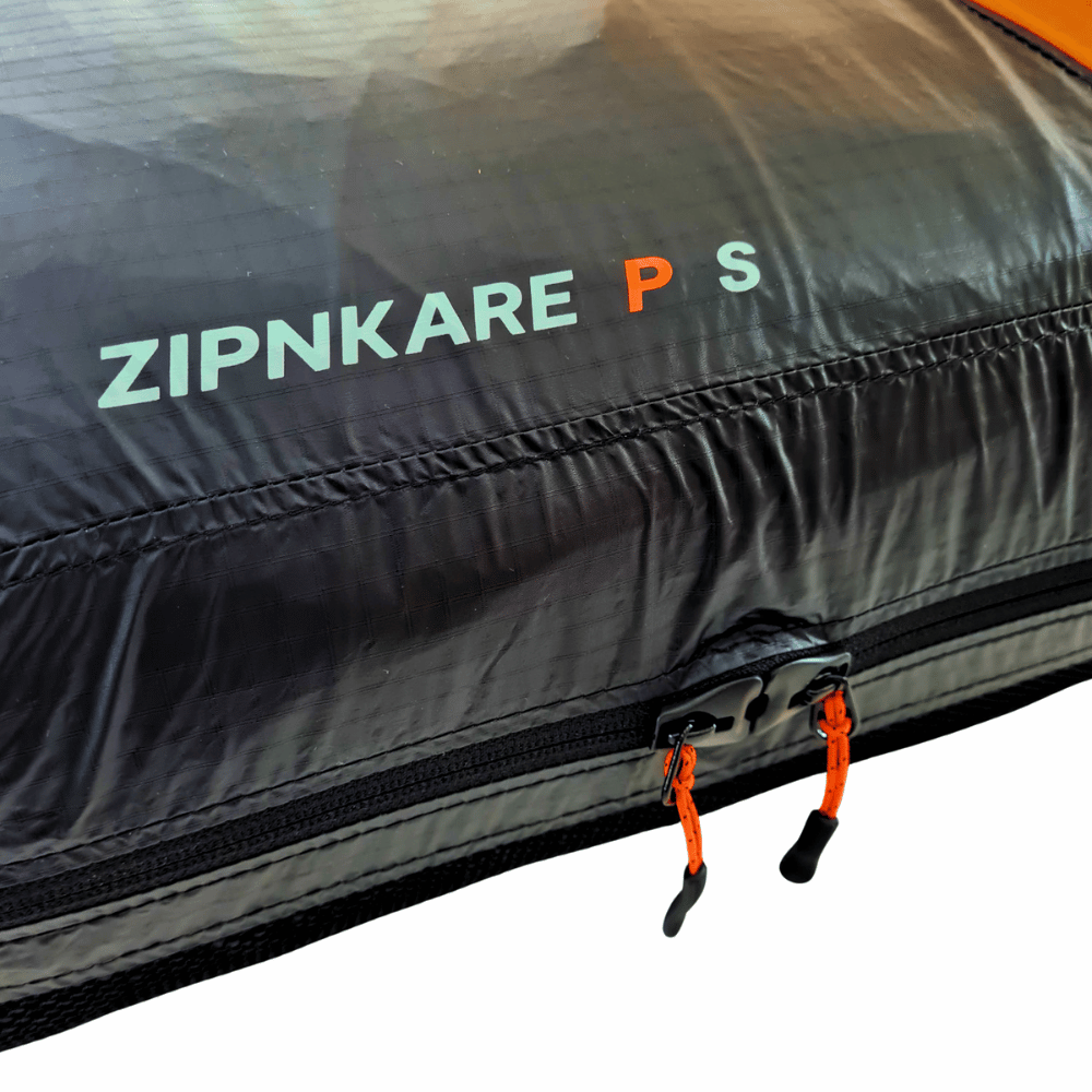 Niviuk ZipNkare P - Compress Tube Bag mit Nahaufnahme von Reißverschluss und Riemen, speziell für ultrakompaktes Packen und Schutz von Leichtschirmen entwickelt.