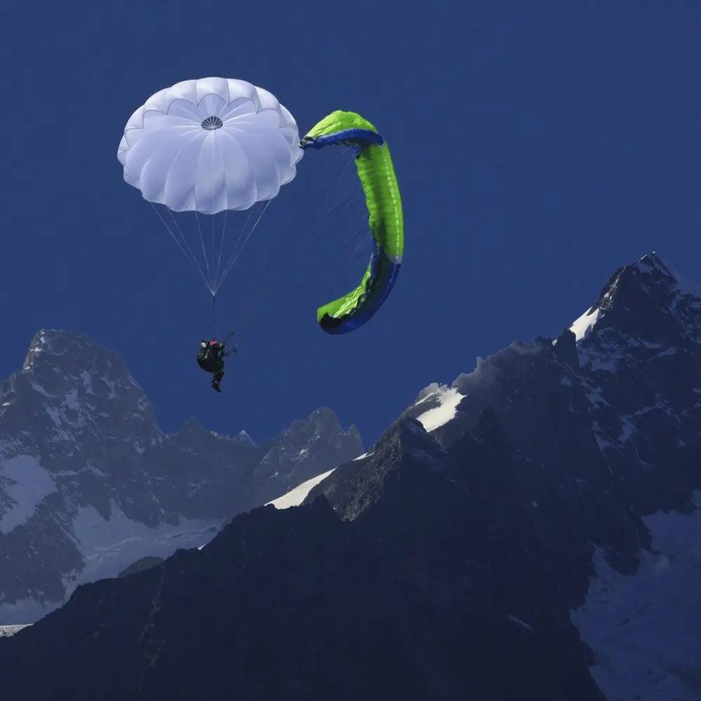 Person schwebt unter Niviuk Cires Rundkappe über schneebedeckten Alpen, demonstriert zuverlässige Rettung und schnelles Öffnen für Gleitschirmflieger.
