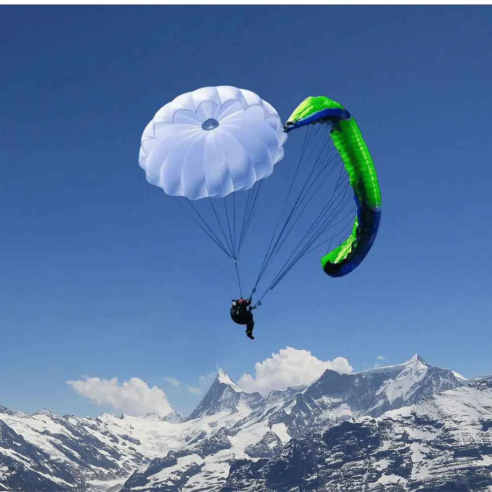 Gleitschirmflieger mit Niviuk Cires Rundkappe über schneebedeckten Bergen; zuverlässiger Rettungsschirm für schnelle Öffnung und Stabilität.
