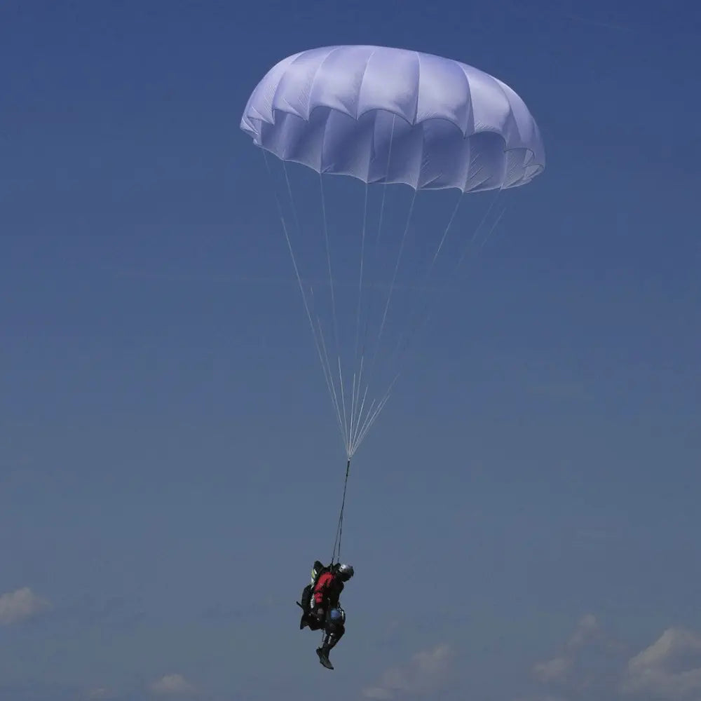 Niviuk Cires Rundkappe, ein Rettungsschirm für Gleitschirmflieger, zeigt einen Springer in der Luft unter einem geöffneten Rundkappenschirm.