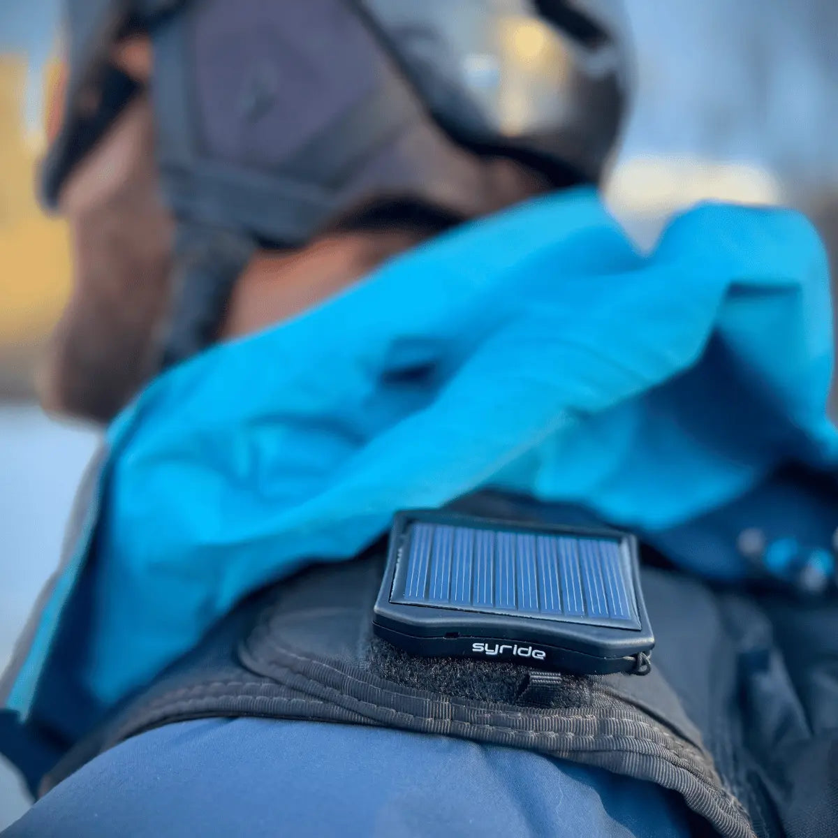 Syride Solar Variometer zum Gleitschirmfliegen, befestigt an der Kleidung eines Piloten mit Helm, ideal für Paragliding und Variometer-Einsatz.