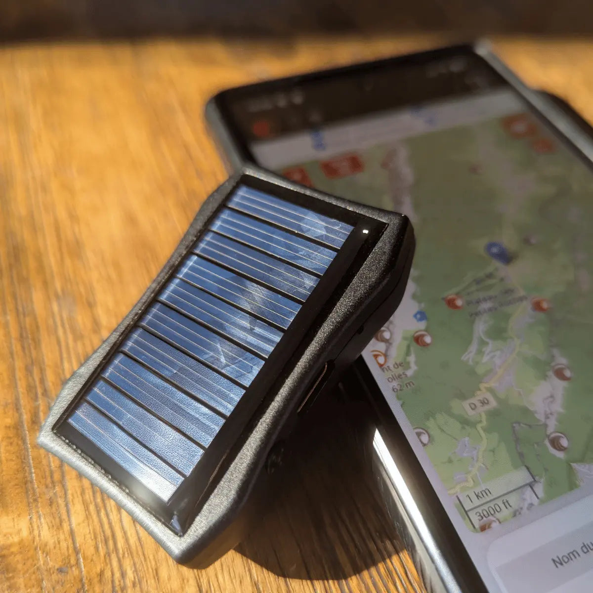 Syride Solar Variometer neben einem Smartphone mit Paragliding-Kartendarstellung, ideal für Gleitschirmflieger und Fly Electronics bei Paragliding24.ch.