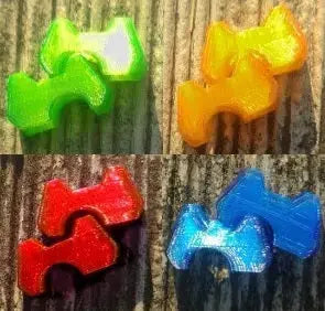 Brummellock - Brummelhaken Sicherung auf Holzoberfläche, flexible Kunststoffteile zur sicheren Verriegelung von Brummelhaken-Verbindungen, ideal für Gleitschirmausrüstung.
