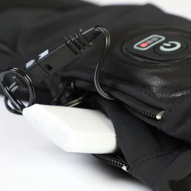 Snowlife Ersatz Akku - 3.7V / 3600mAh, abgebildet neben einem schwarzen Beutel mit Kabel, passend für Snowlife Heizhandschuhe, ideal für Outdoor-Aktivitäten.