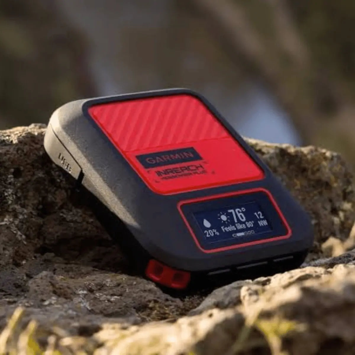 Robustes, schwarzes und rotes Garmin inReach Messenger Plus Outdoor-Kommunikationsgerät mit Display, das Wetterdaten anzeigt, auf Felsen liegend.
