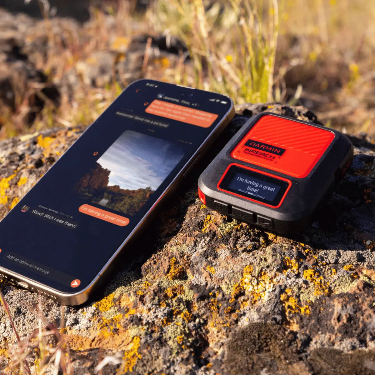 Garmin inReach Messenger mit Smartphone in felsiger Outdoor-Umgebung, zeigt Satellitenkommunikationsgerät und Nachrichten-App.