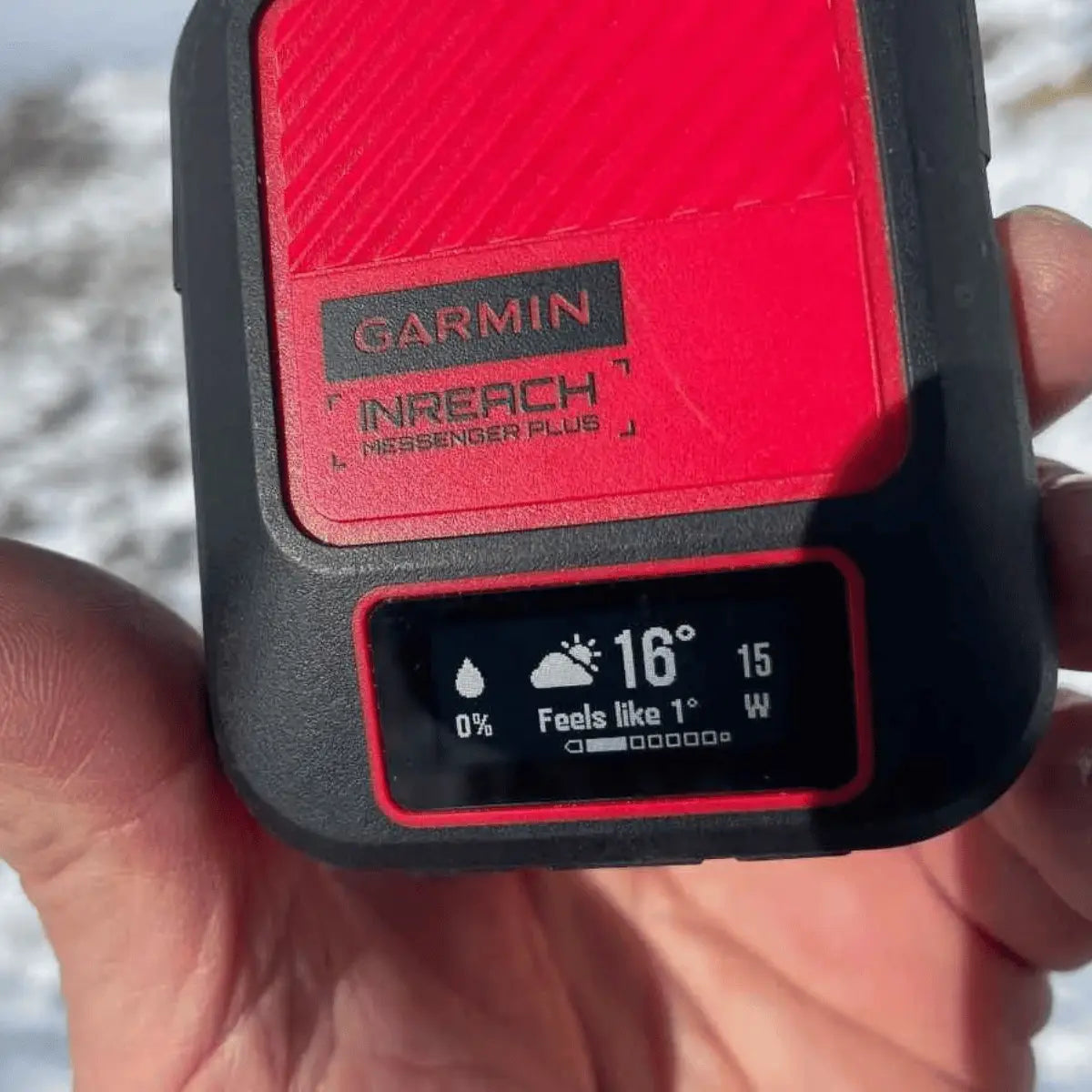 Garmin inReach Messenger Plus Satellitentelefon mit Wettervorhersage und Batterieanzeige auf dem Display, gehalten in einer Hand.