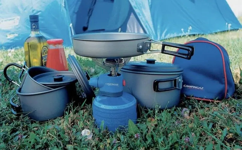 Campingaz Biwak Geschirrset 8-tlg. auf Gras, bestehend aus Töpfen, Pfanne und Deckeln, ideal für Camping, kompakt, robustes eloxiertes Aluminium.