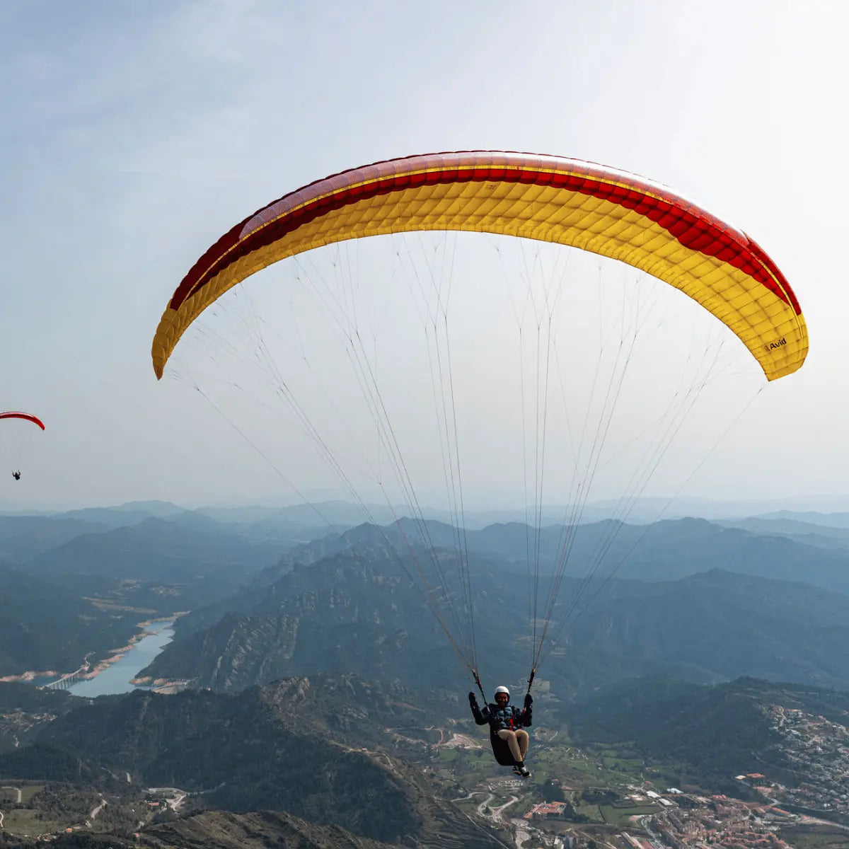 GIN Avid (High EN-B) Gleitschirm, perfekt für Streckenflieger. Abgebildet sind Personen beim Paragliding in der Luft.