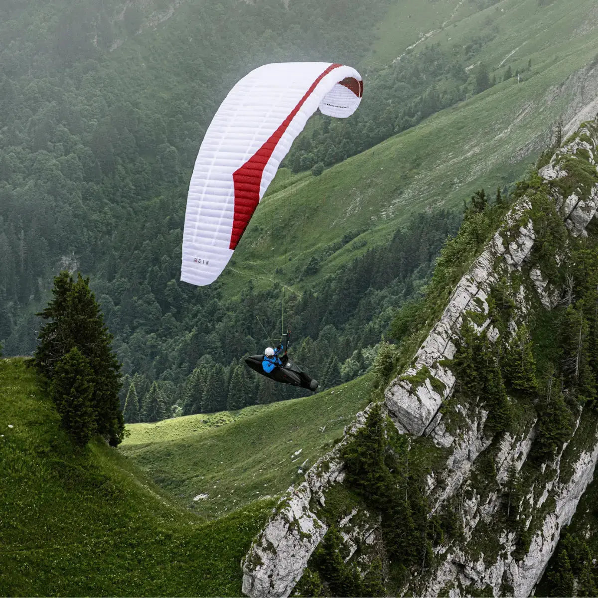 Gin Bonanza 3 (EN-C) Gleitschirm gleitet über steilen Bergkamm, ideal für erfahrene Piloten, die Leistung und Stabilität in alpinen Bedingungen suchen.