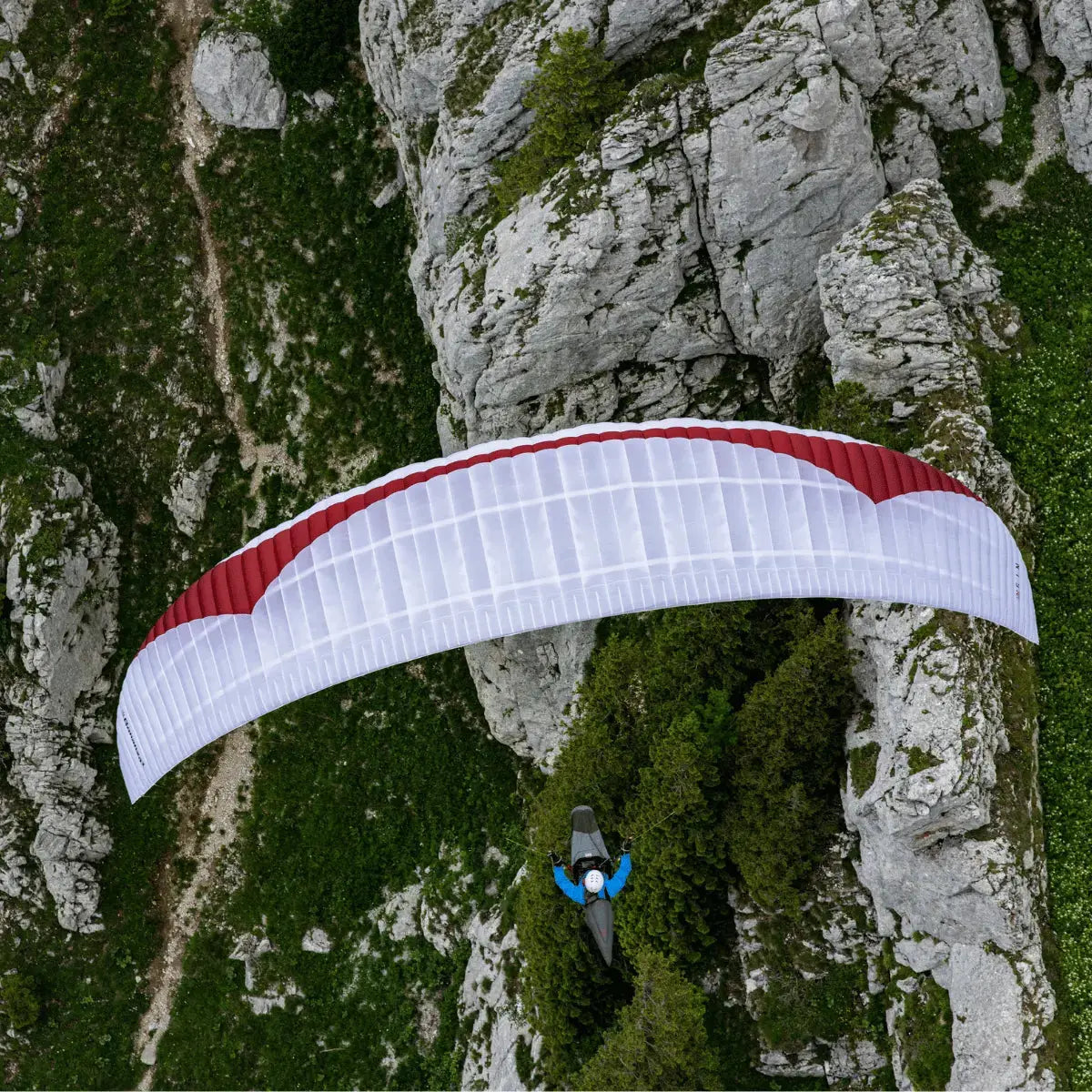Gin Bonanza 3 (EN-C) in Aktion: Paraglider fliegt über alpines Gelände. Hochleistungsschirm für erfahrene Piloten, ideal für Thermik und XC-Flüge.