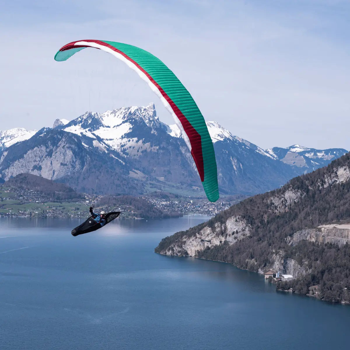 Gin Boomerang 12 EN-CCC Paraglider in der Luft über Bergsee; designed für erfahrene Wettbewerbspiloten, bietet maximale Leistung und Präzision für anspruchsvolle XC-Flüge.