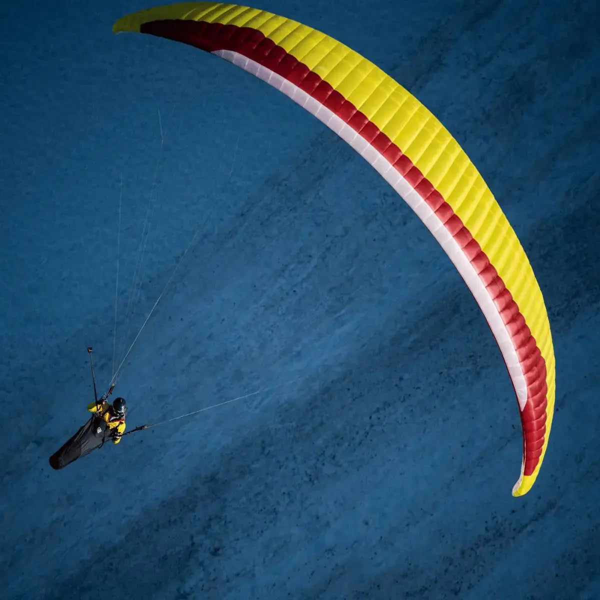 Person fliegt mit dem GIN Explorer 2 Gleitschirm, bekannt für seine exzellente Steigleistung und Stabilität, ideal für Abenteuer im Gleitschirmsport.