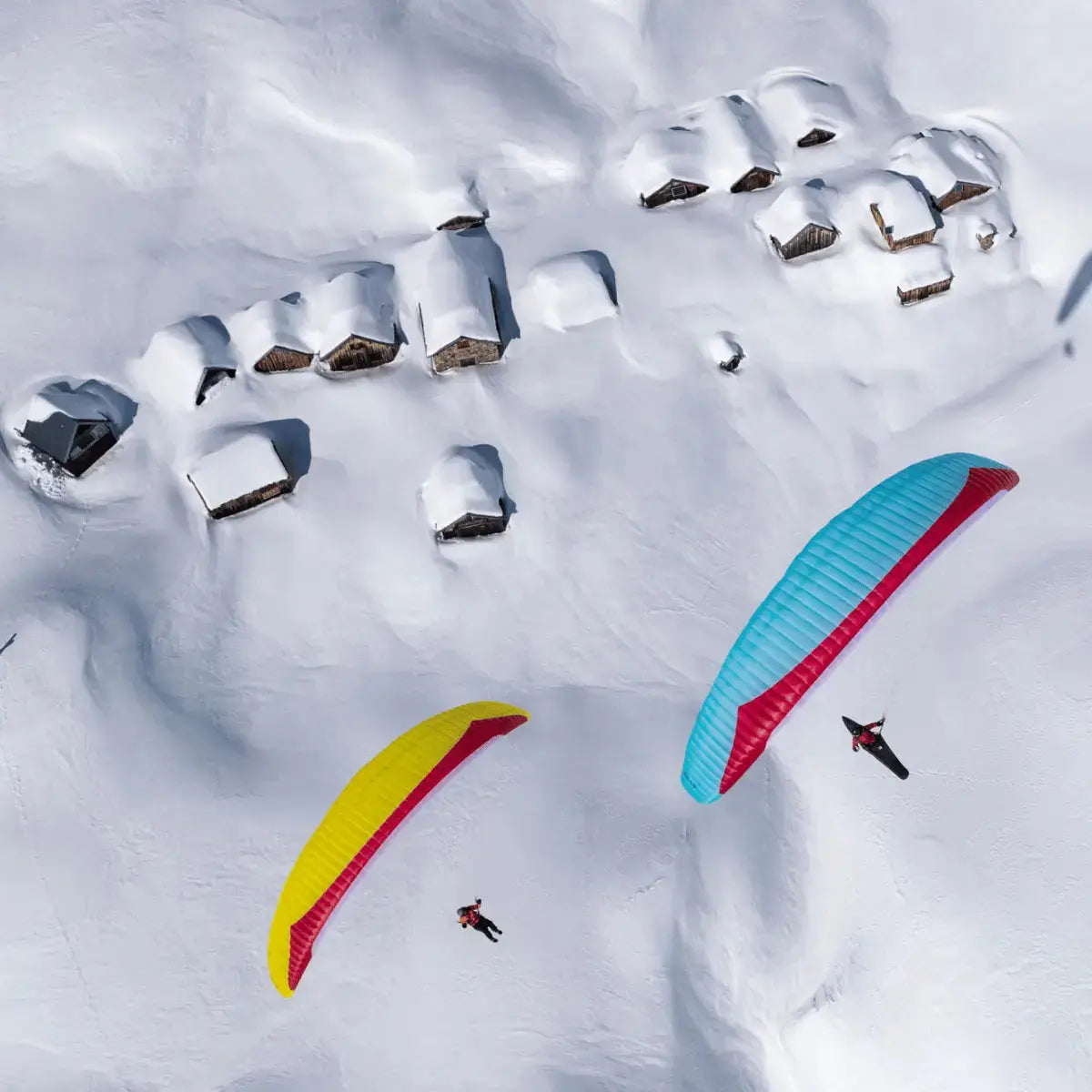 GIN Explorer 2 (High EN-B) im Einsatz beim Paragliden Schnee bedeckten Häusern, zeigt seine herausragende Leistung und Stabilität in der Luft. Ideal für Abenteuersportler.