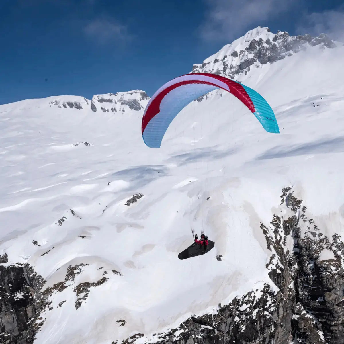 Person fliegt den GIN Explorer 2 Gleitschirm über verschneitem Berg, ideal für Abenteuer und Spitzenleistung. Perfekt für Paragliding-Enthusiasten bei Paragliding24.ch.