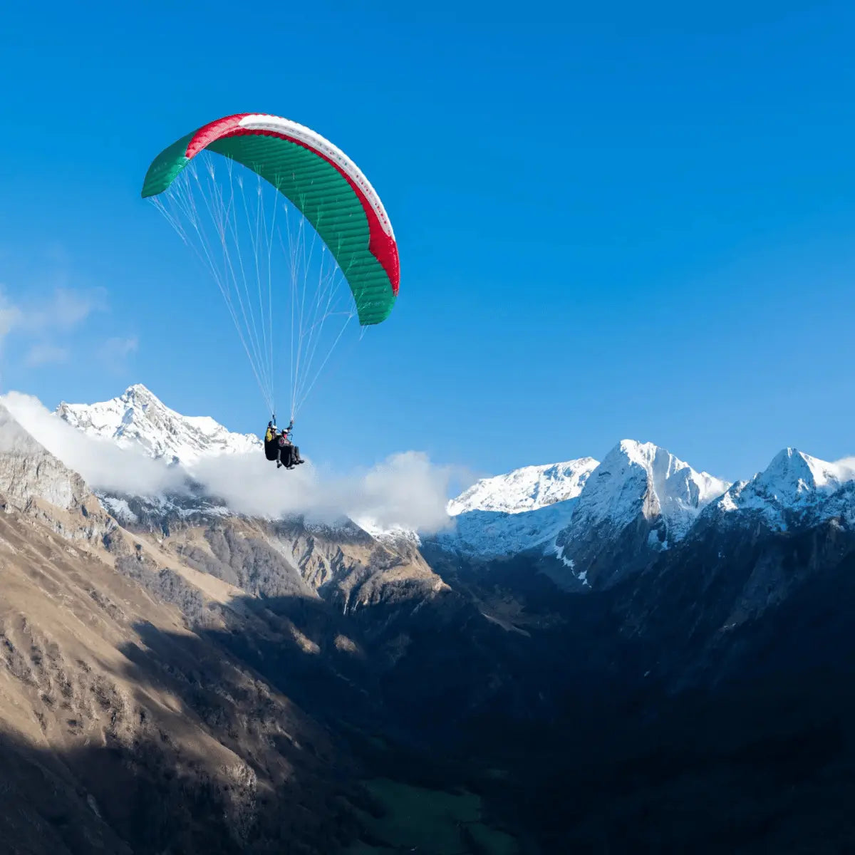 Tandemflug mit Gin Fuse 4 Tandem EN-B Gleitschirm über Bergtal, ideal für professionelle Piloten und Flugschulen, bietet Stabilität und einfache Starts.