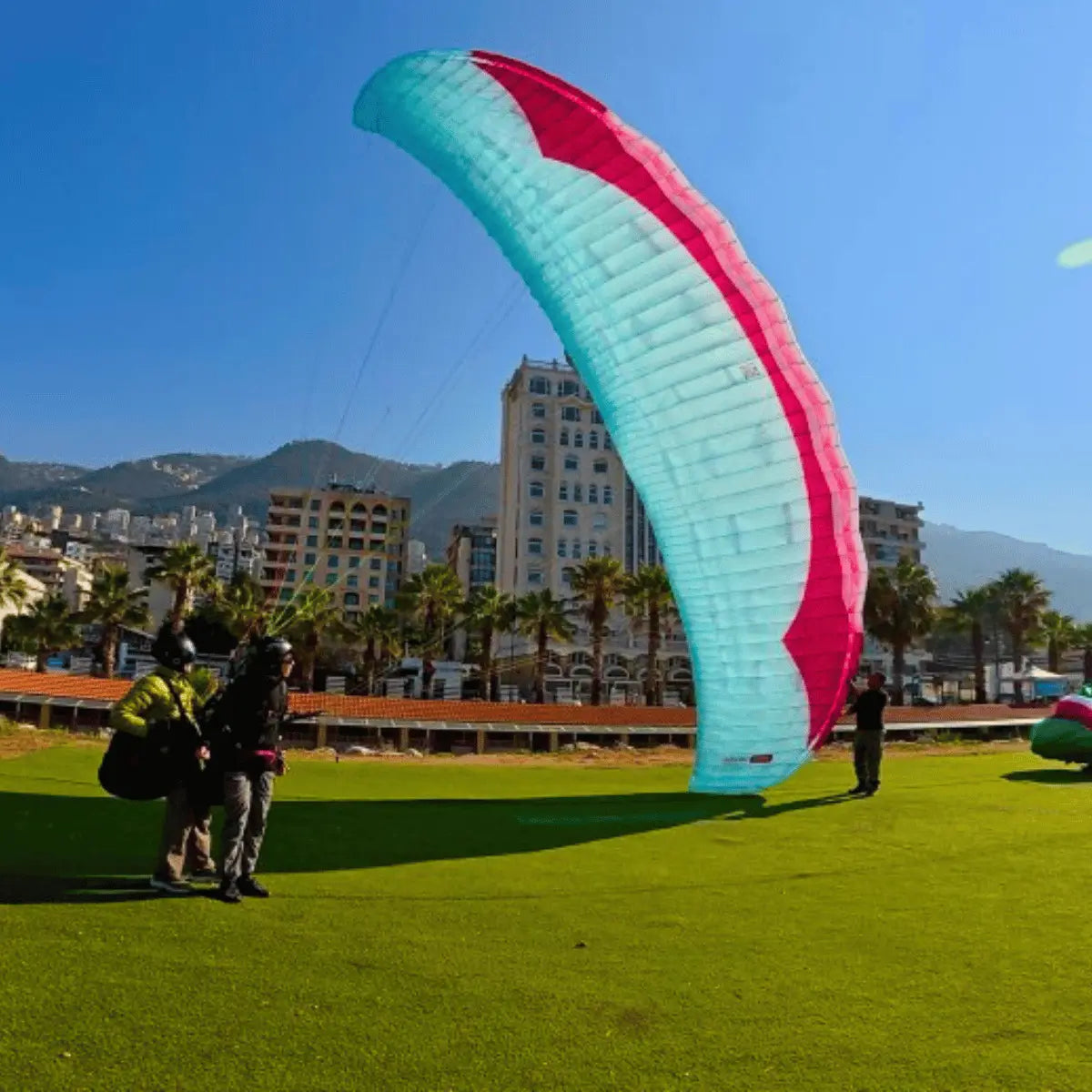 Tandem-Paragliding-Setup im Gras mit Gin Fuse mini (EN-B) Strong Wind Tandem-Gleitschirm, ideal für erfahrene Piloten bei anspruchsvollen Windbedingungen.