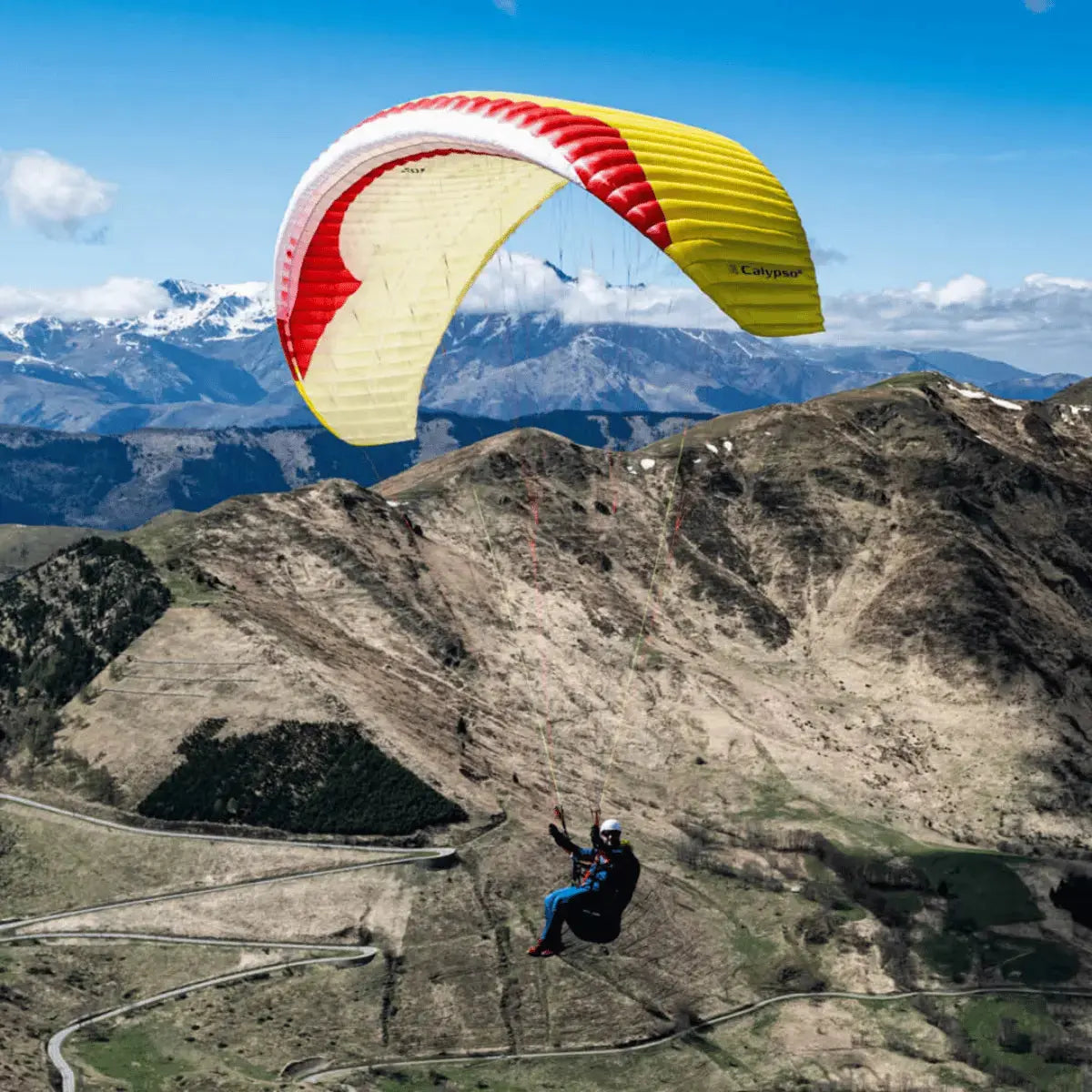 Paraglider Gin Calypso 2 Light (Low EN-B) über Gebirgslandschaft, ideal für Thermik und Streckenflüge, bietet Sicherheit und Performance für ambitionierte Piloten.