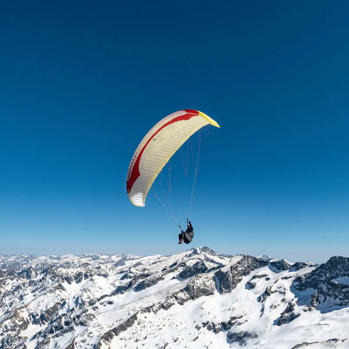 Gin Calypso 2 Light (Low EN-B) Gleitschirm über schneebedeckten Bergen, ideal für Thermik, Streckenflüge und Hike & Fly, bietet präzises Handling und hohe Leistung.