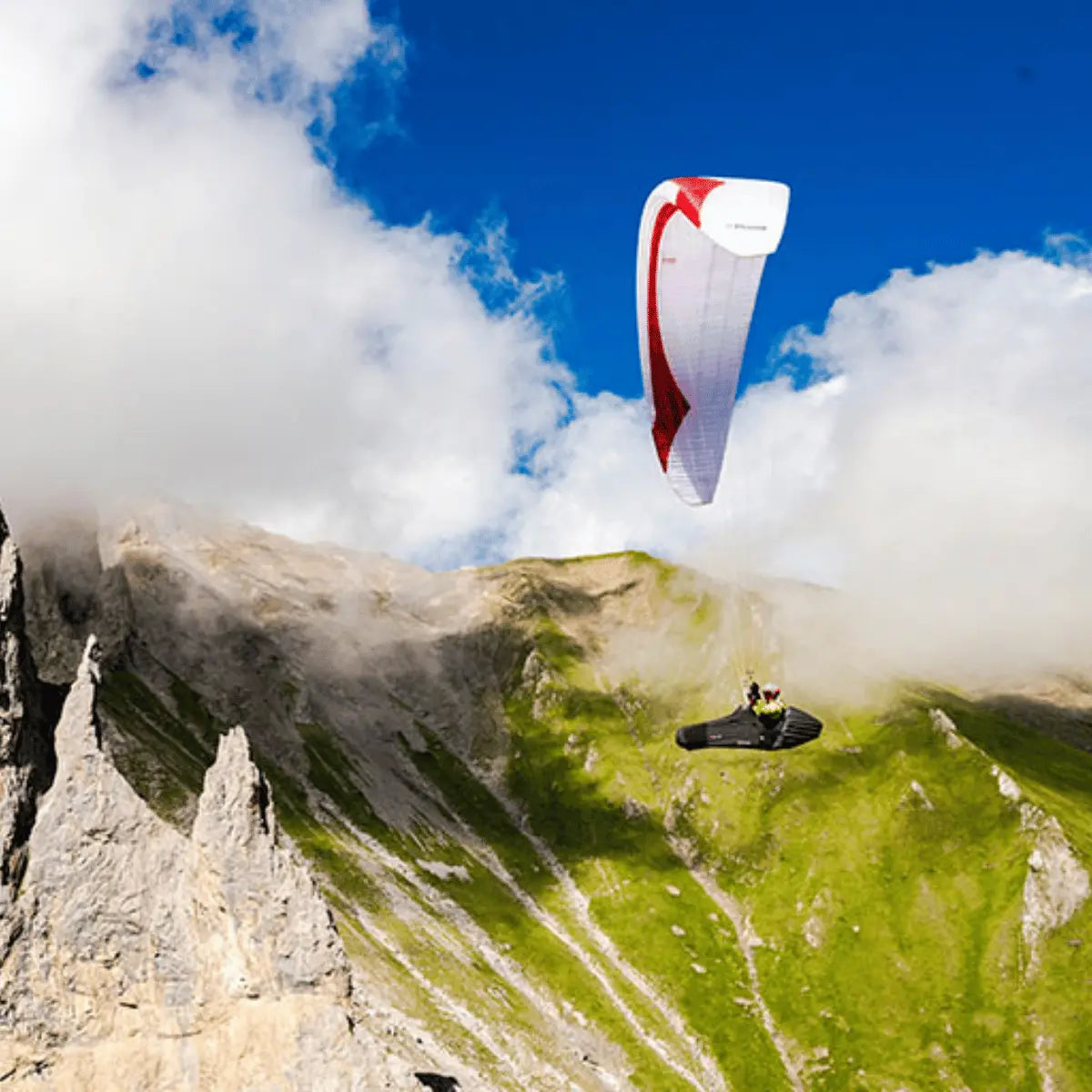 Gin Puma Light (EN-D) im Flug über Berggrat, bietet maximale Leistung bei minimalem Gewicht für erfahrene XC- und Wettkampfpiloten. Perfekt für alpines Gelände.