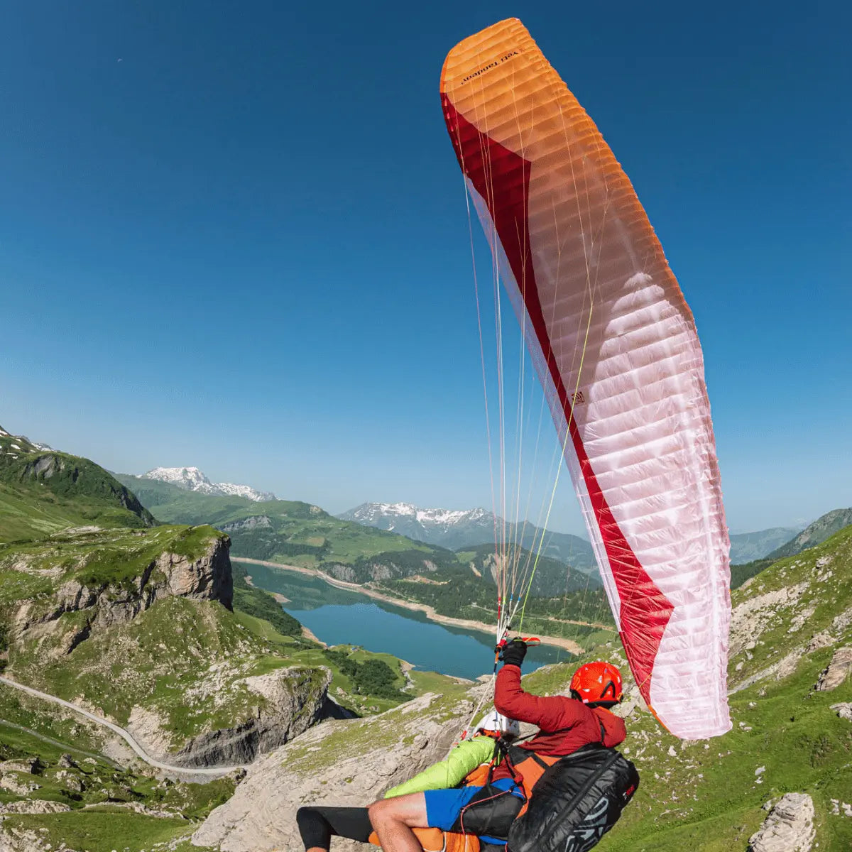 Pilot fliegt mit Gin Yeti Tandem 3 (EN-A) Hike & Fly Tandem über Berglandschaft, symbolisiert Leichtigkeit und Sicherheit in alpinen Abenteuern.