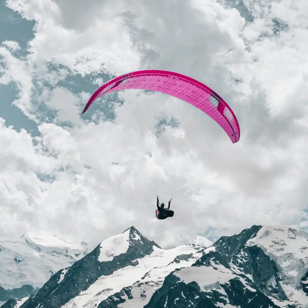 Person fliegt mit Niviuk Artik 7 P Gleitschirm über verschneitem Berg, ideal für XC und Hike & Fly, ultraleicht und leistungsstark.