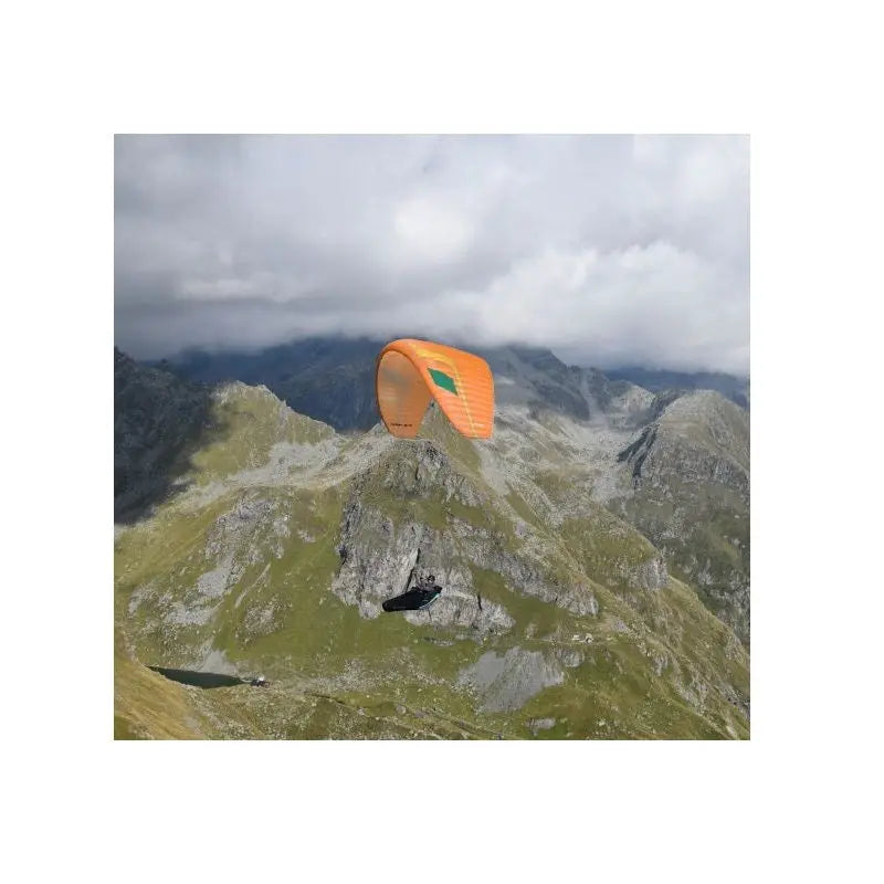 Niviuk Hook 6 P Leichtschirm fliegt über Berglandschaft, zeigt Vielseitigkeit und hervorragende Thermikeigenschaften, ideal für Bergsteigen und Fliegen.