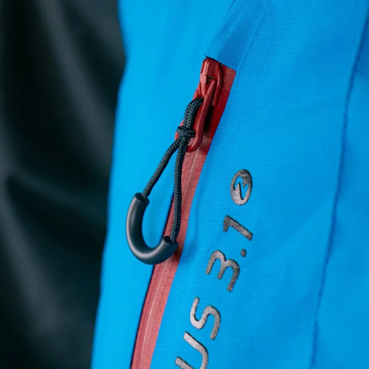 Nahaufnahme eines Reißverschlusses der Aventus 3.1, einer robusten Gleitschirmjacke mit innovativen Funktionen für alle Jahreszeiten von Paragliding24.ch.