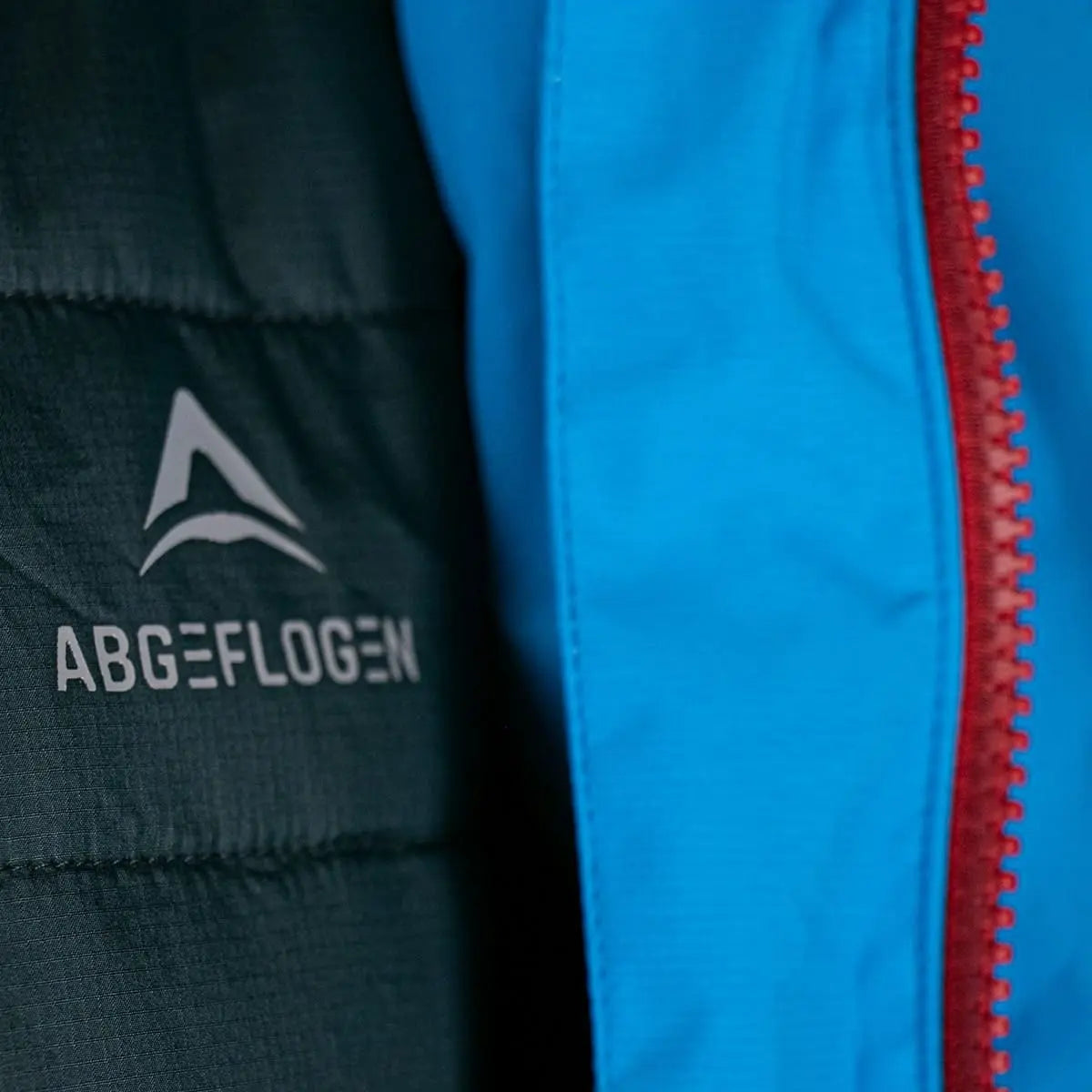 Aventus 3.1 Gleitschirmjacke mit hochwertigem YKK-Reißverschluss und Logo, zeigt Details wie Ripstopgewebe und ergonomischen Schnitt, ideal für Paragliding.